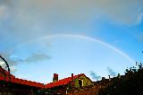 Arcobaleno sottile sopra bella casa rossa