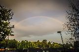 Immagine sottile Arcobaleno sottile sopra bosco vicino a città