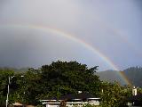 Arcobaleno su villa con albero molto grande