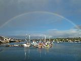 Immagine arcobaleno Arcobaleno sul mare quieto con tante belle barche
