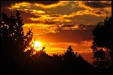 Immagine bel Bel tramonto con sole e nuvole tra alberi