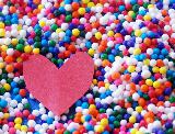 Immagine cartoncino Cartoncino a forma di cuore su caramelle colorate