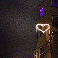 Cuore a neon che illumina con dolcezza la strada di notte