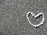 Immagine cuore Cuore bianco costituito da pietre su sabbia molto fine