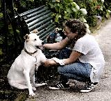 Donna che coccola un bel cane bianco nel parco