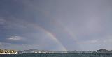 Immagine doppio Doppio arcobaleno che sovrasta il mare con dietro le montagne