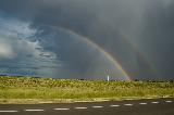 Immagine doppio Doppio arcobaleno che sparisce in un cielo molto nuvoloso