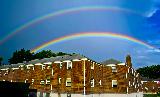 Immagine bel Doppio arcobaleno in bel cielo blu che sovrasta case americane