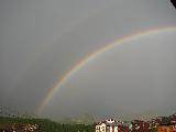 Doppio arcobaleno in brutto cielo plumbeo