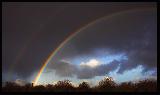 Immagine temporale Doppio arcobaleno in cielo annerito per il temporale