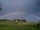 Doppio arcobaleno in cielo blu sopra campagna