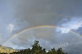 Immagine doppio Doppio arcobaleno in cielo nuvoloso tendente al celestino