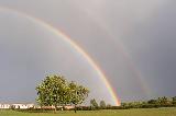 Doppio arcobaleno in grande cielo grigio