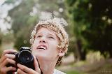 Fotografo biondo che guarda in alto con meraviglia