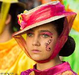 Giovane ragazza in maschera per carnevale con cappello sgargiante