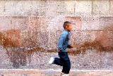 Giovane ragazzo che corre in Messico con sfondo di grande muro