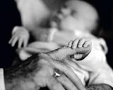 Immagine neonato Neonato che stringe in mano il dito del nonno con tenerezza
