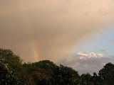 Pezzo di arcobaleno verso le grigie nuvole