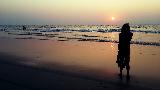 Ragazza sulla spiaggia in India al tramonto