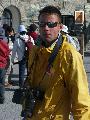 Immagine impermeabile Ragazzo in impermeabile giallo con macchina fotografica a passeggio