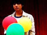 Immagine ragazzo orientale Ragazzo orientale con espressione seria con tre palloncini colorati