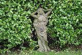 Immagine statua Statua di ragazza che si tocca simpaticamente la testa in giardino