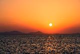 Immagine lontananza Tramonto sul mare calmo con montagne in lontananza