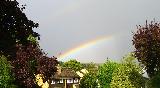Immagine tratto Tratto di arcobaleno che sembra partire da bella villa nel verde