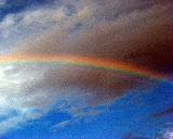 Tratto di arcobaleno in cielo azzurro con brutta nuvola